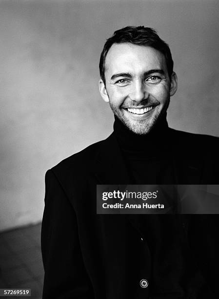 a man dressed in black clothes, smiling, looking at the camera, portrait (b&w). - man in black suit stock pictures, royalty-free photos & images