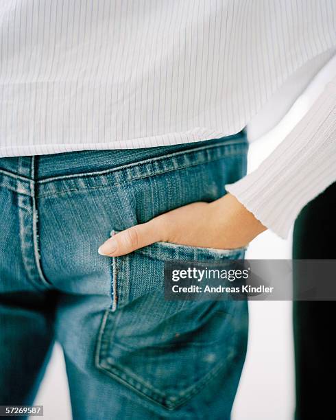 a hand in a hip pocket on a pair of jeans. - male female pair stockfoto's en -beelden