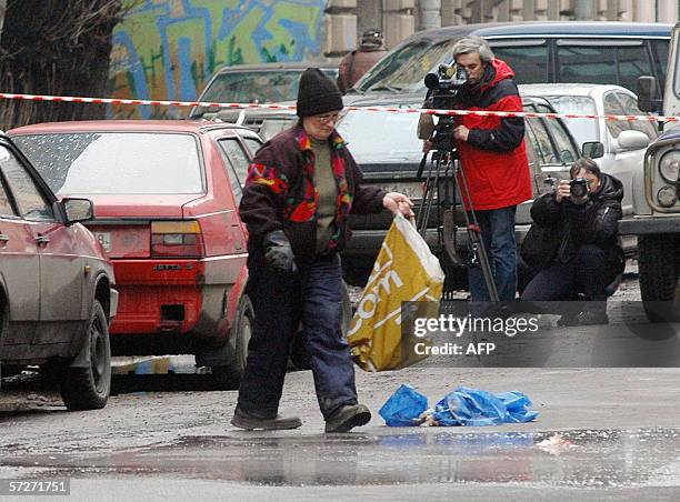 Moscow, RUSSIAN FEDERATION: A municipal worker cleans the place, where a student from Senegal was killed, in Saint-Petersburg 07 April 2006. A...