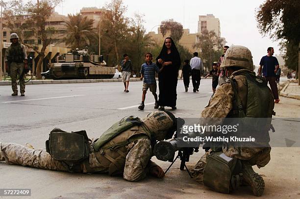 Iraqis look at U.S marines on April 9, 2003 near the at al-Fardous square in Baghdad, Iraq. The third year anniversary since the overthrow of Saddam...