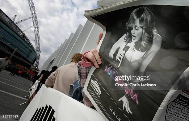 Madonna fan reads a paper as she queues to get hold of the first tickets to be sold for pop icon Madonna's summer concerts as they go on sale at...