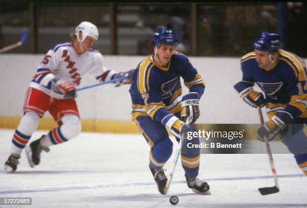 American professional hockey player Joe Mullen , forward for the St. Louis Blues, skates with the puck during a game with the New York Rangers at...