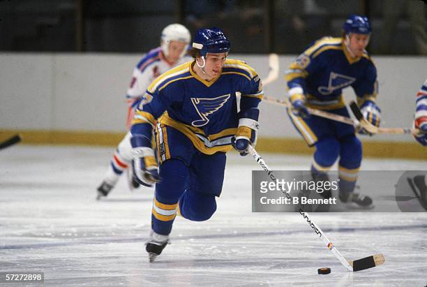 American professional hockey player Joe Mullen , forward for the St. Louis Blues, follows the puck during a game with the New York Rangers at Madison...