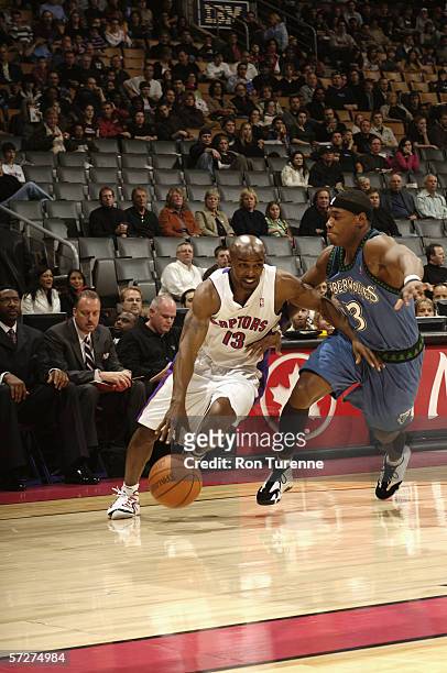 Mike James of the Toronto Raptors drives around Marcus Banks of the Minnesota Timberwolves during the game on March 24, 2006 at the Air Canada Centre...