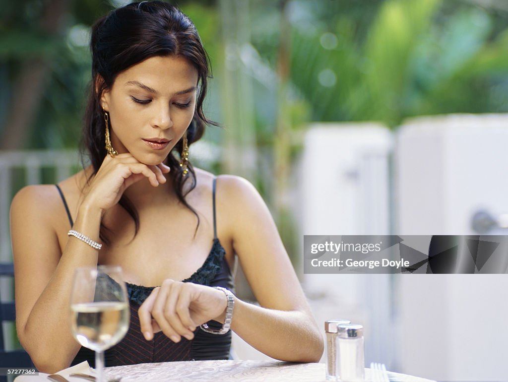 Portrait of a young woman looking at her watch