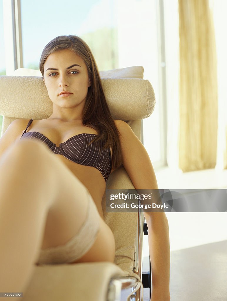 Portrait of a young woman reclining on a chaise lounge