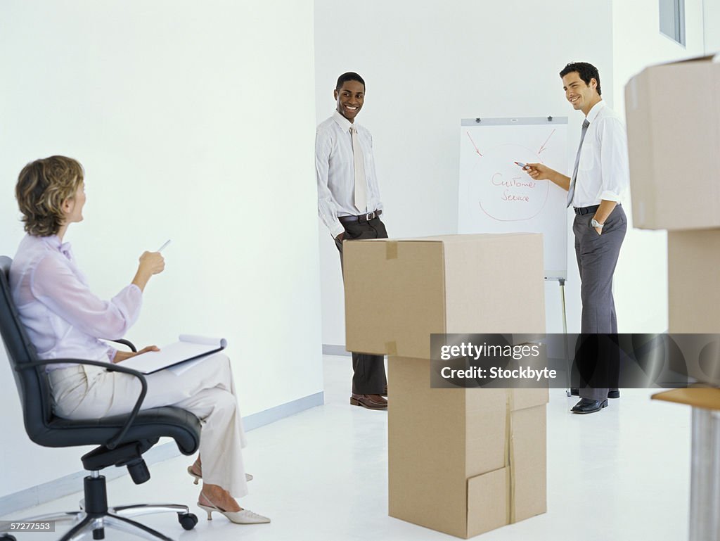 Portrait of businesspeople in empty office with cardboard boxes