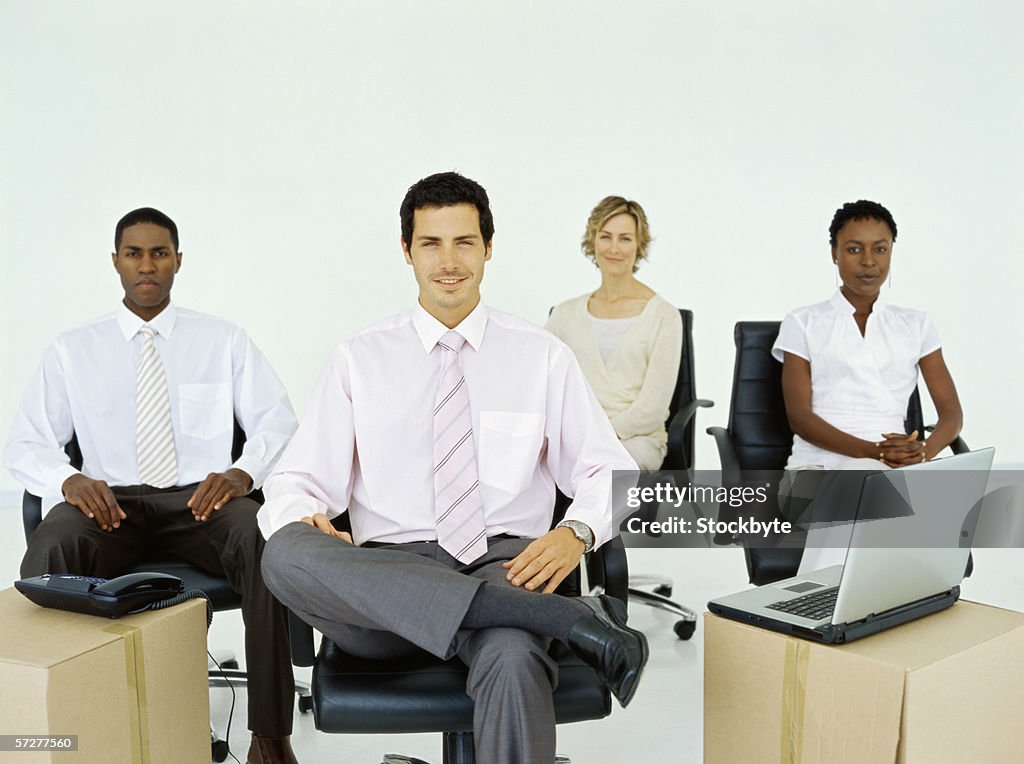 Portrait of businesswomen and businessmen sitting and looking at camera.