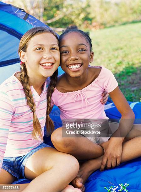 portrait of two girls outside a tent, smiling - only girls stock pictures, royalty-free photos & images