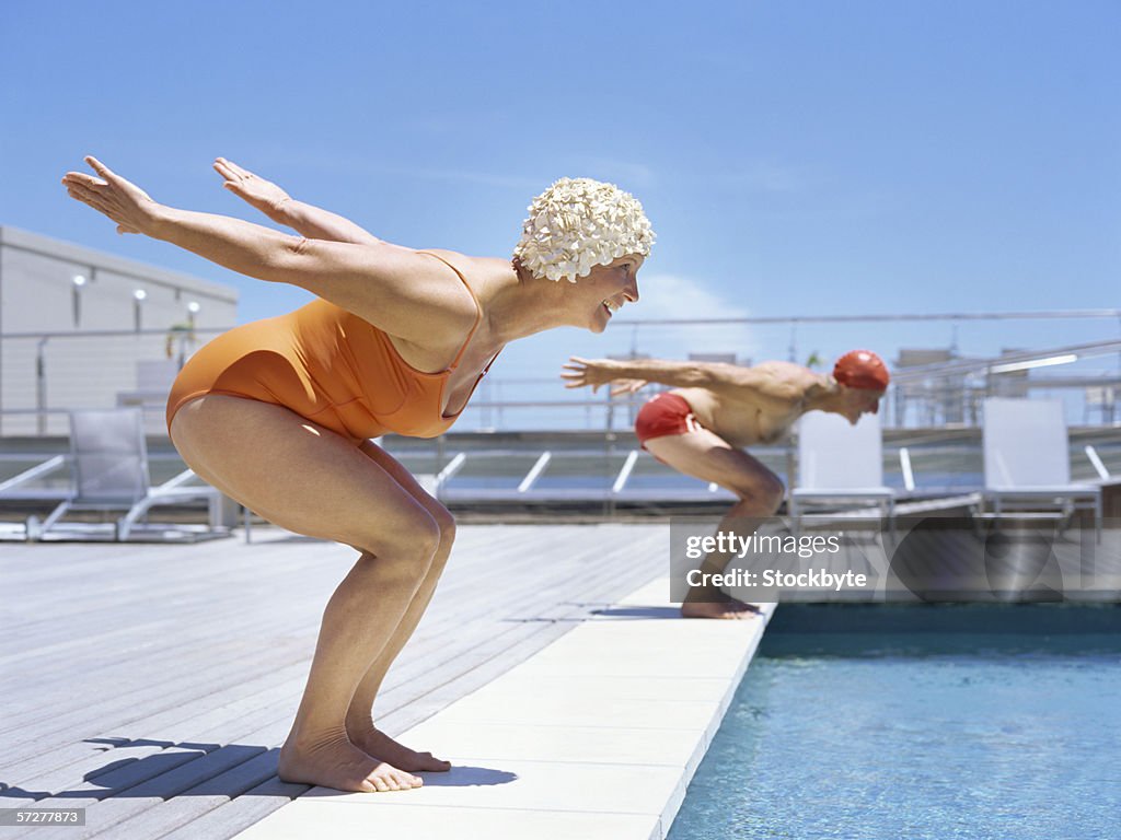 Senior couple ready to dive in to swimming pool