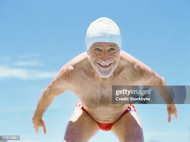 senior man ready to dive in to swimming pool - old people diving stock pictures, royalty-free photos & images