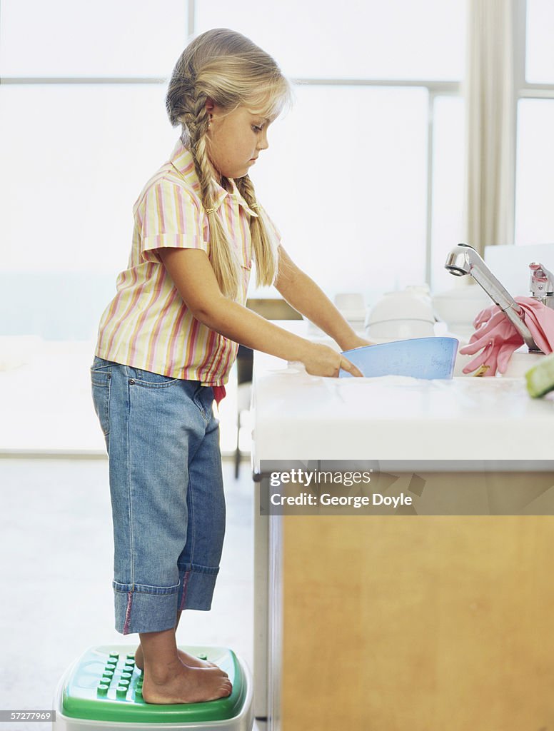 Side profile of a girl washing dishes