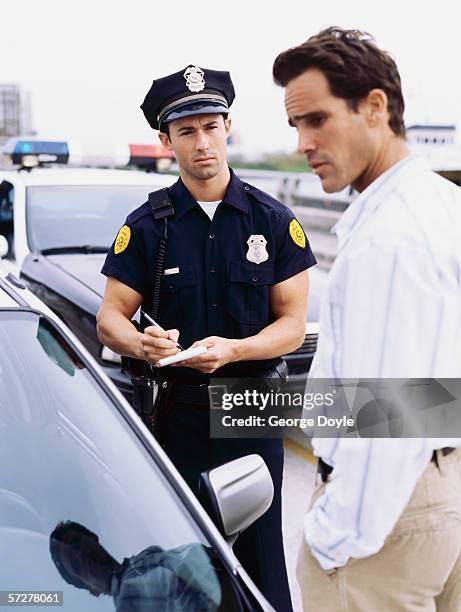 side profile of a policeman and a mid adult man - bobby george stock pictures, royalty-free photos & images