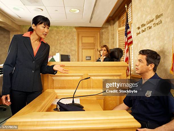 side profile of a witness and a lawyer on the witness stand, with the judge listening - 証人 ストックフォトと画像