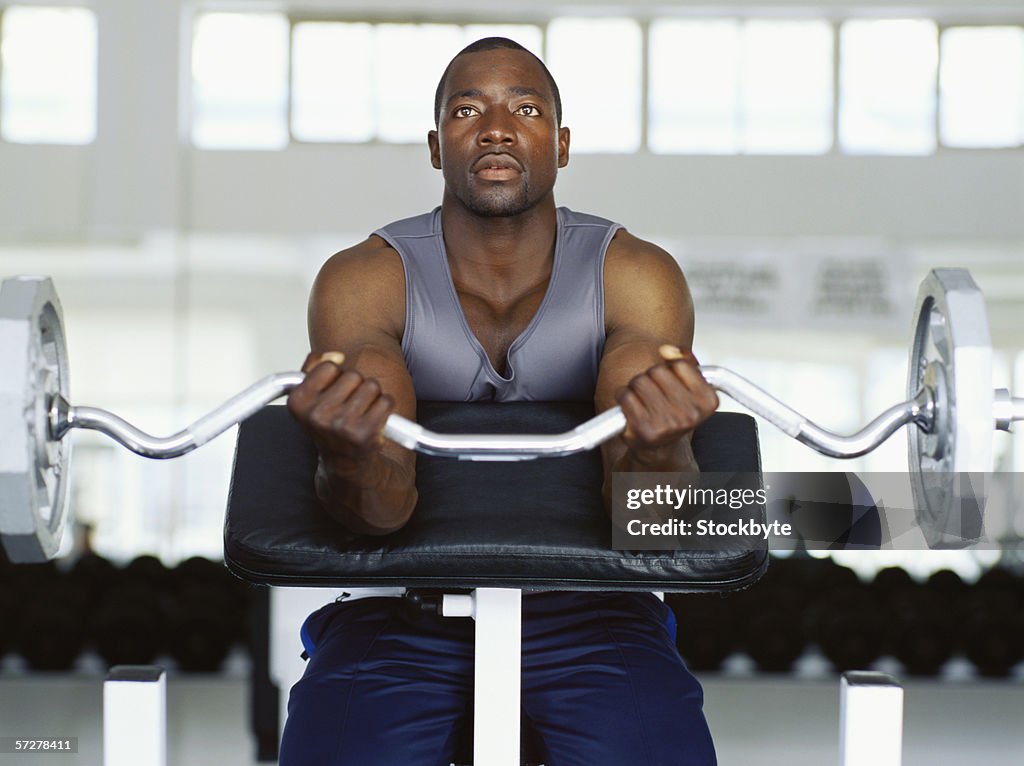 Mid adult man exercising in the gym with weights