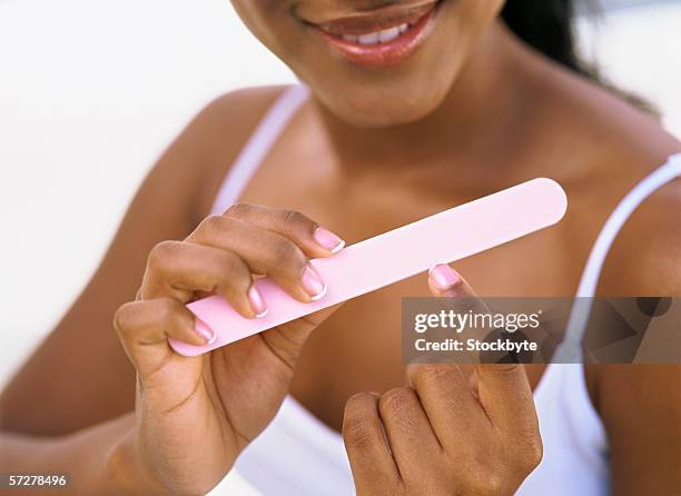 mid section of a woman using a nail file - au milieu de limage photos et images de collection