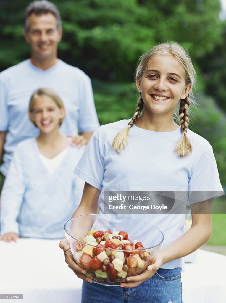 Portrait of a girl holding bowl of fruit