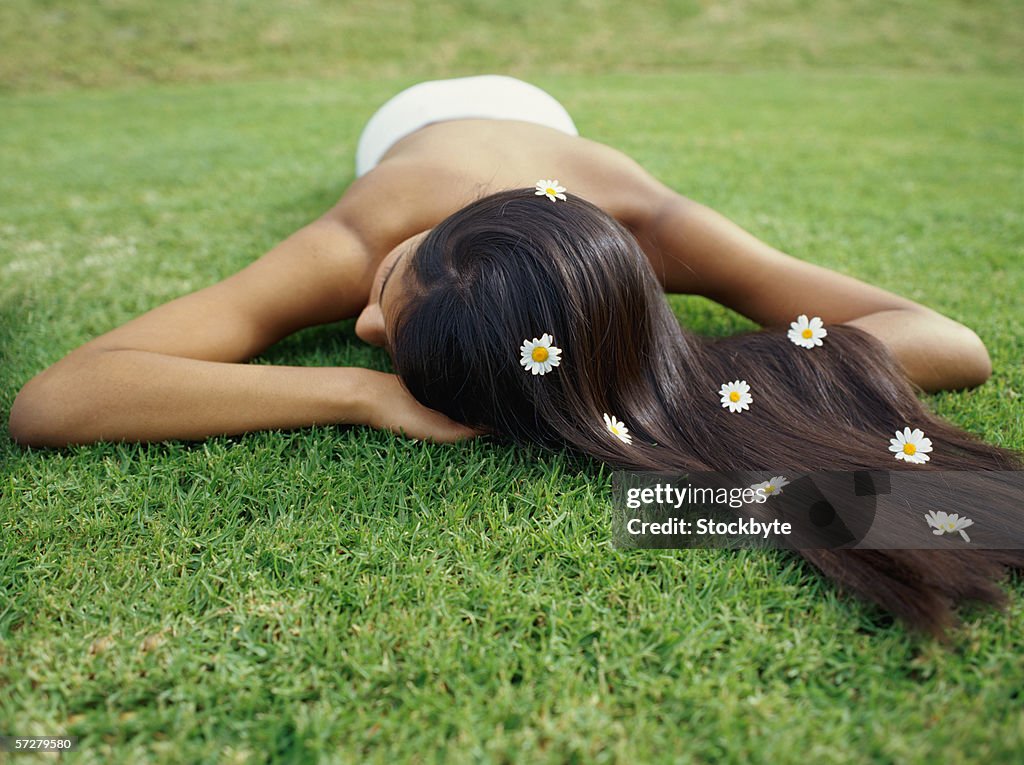 Close-up of a young woman lying on grass