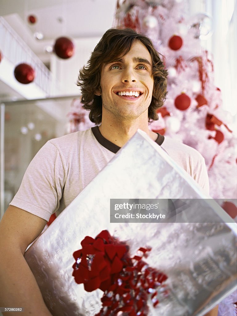 Low angle view of a young man holding a gift