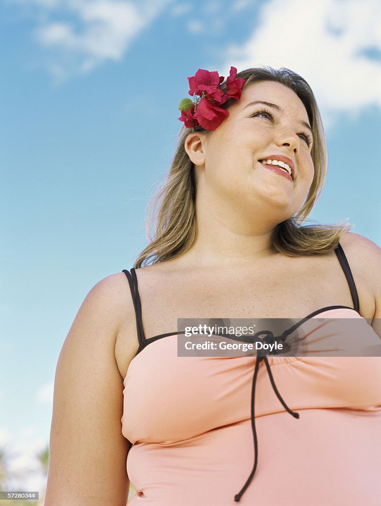 Low angle view of an overweight young woman standing on the beach