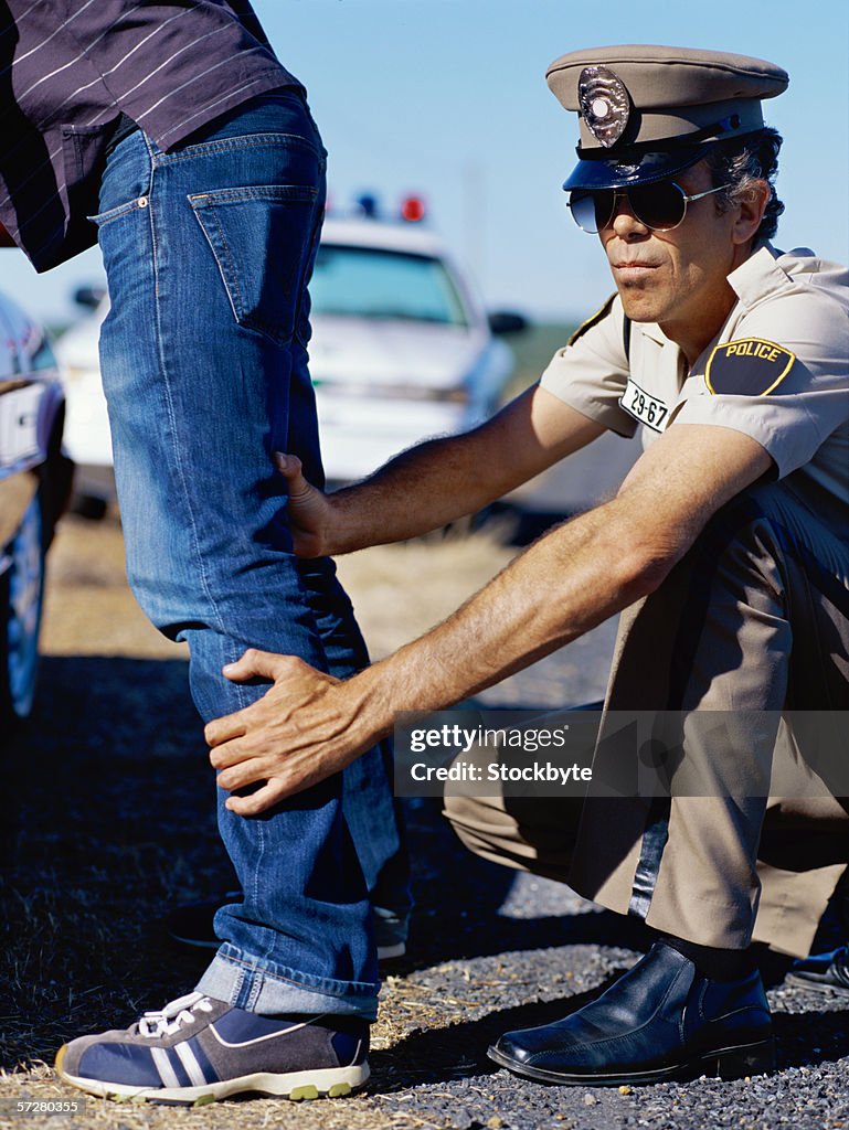 Low angle view of policeman checking a young man