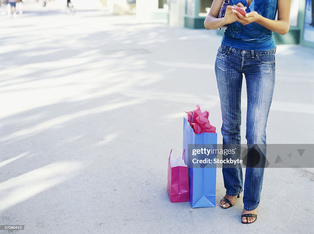 Low section of a woman using her mobile phone