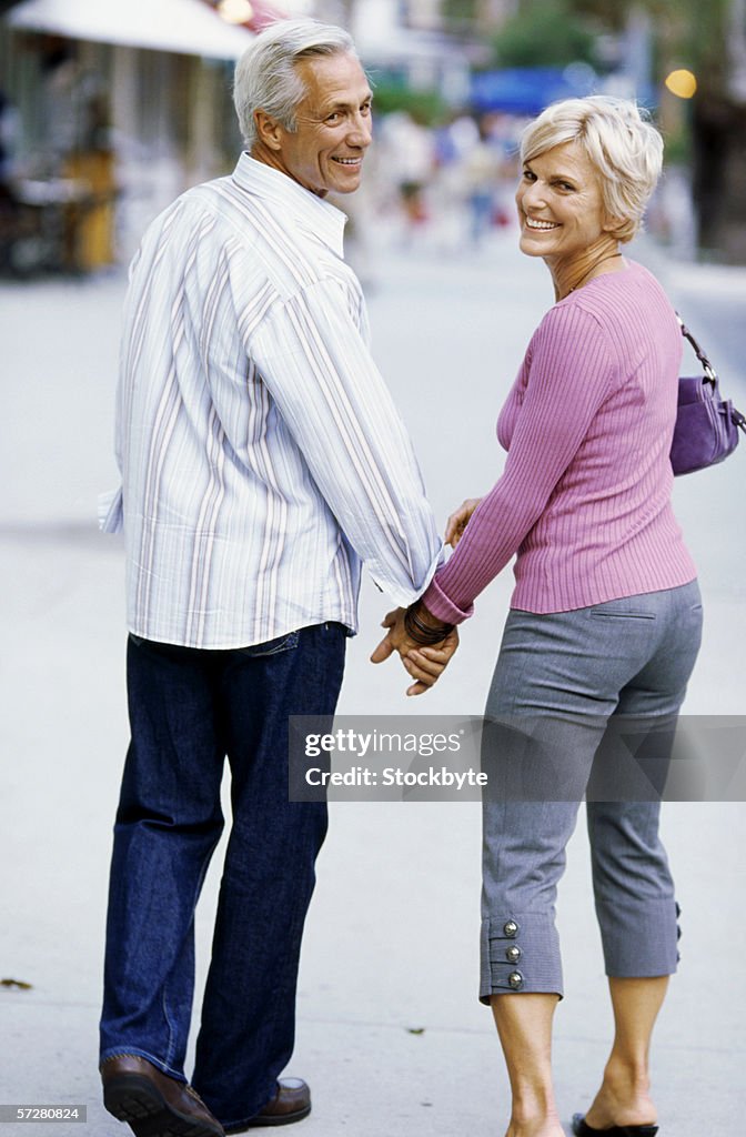 Rear view of a mature couple walking and holding hands
