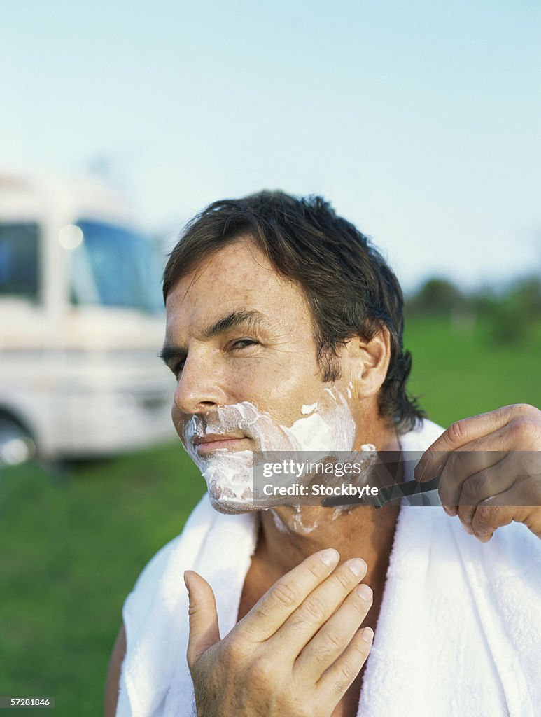 Close-up of a mid adult man shaving