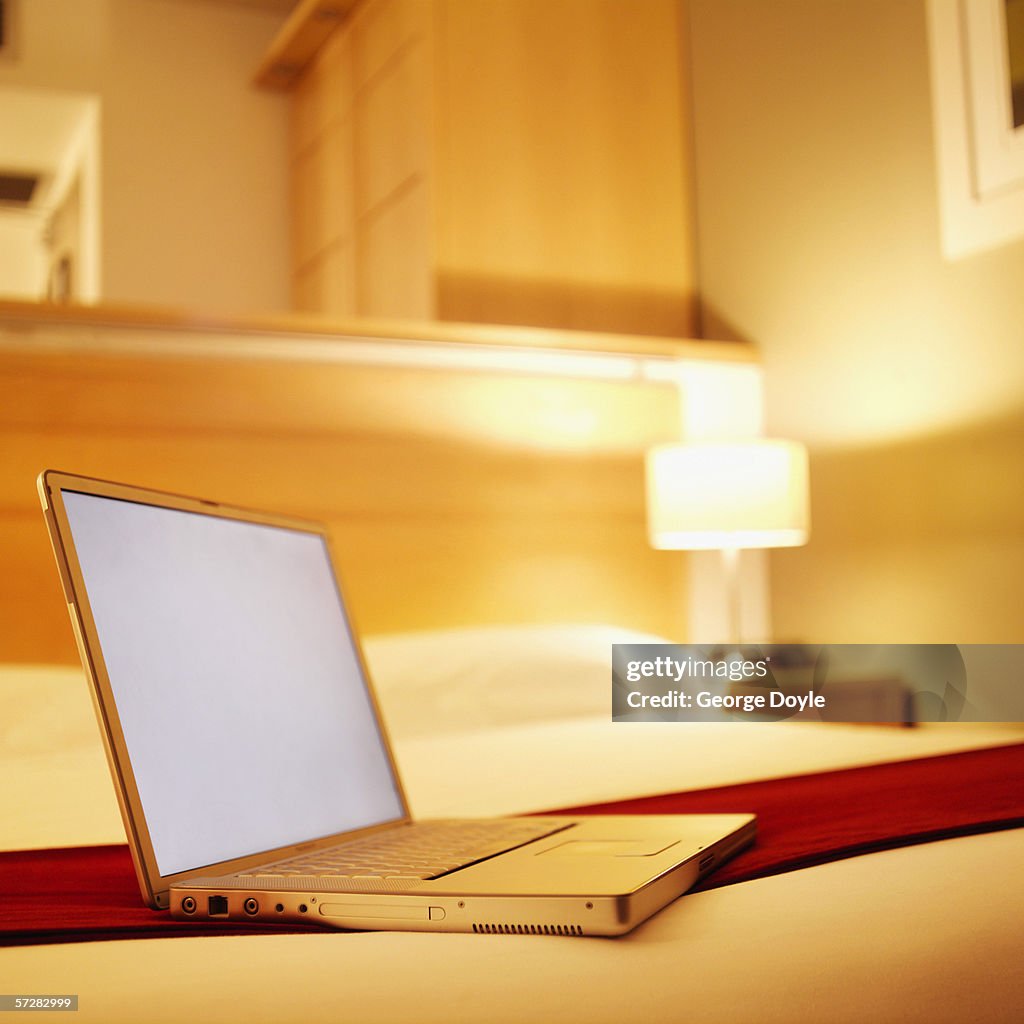 View of laptop on bed in hotel room