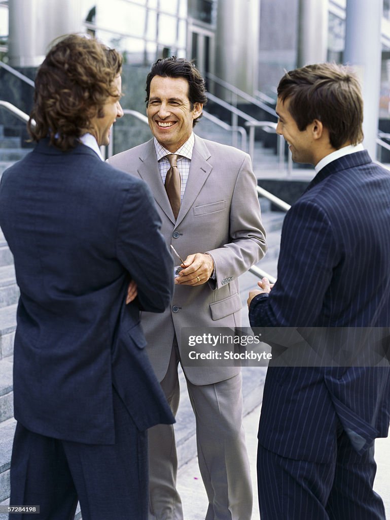 Three businessmen standing and talking