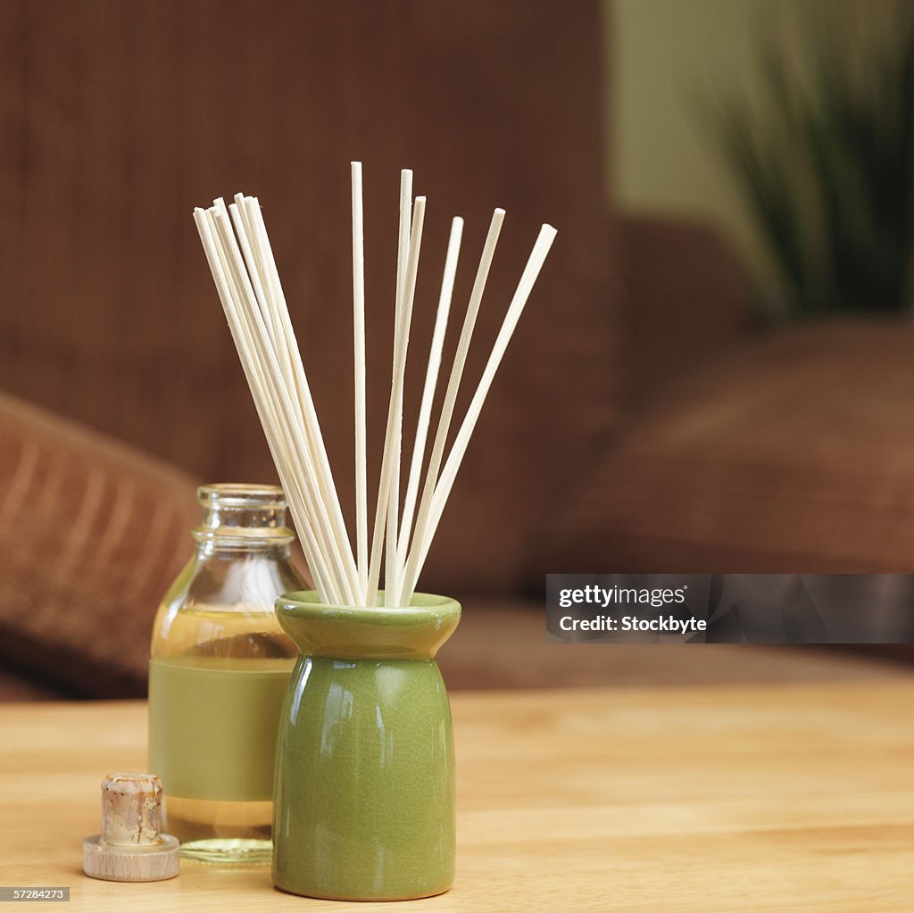 Incense sticks in a burner with bottle of oil