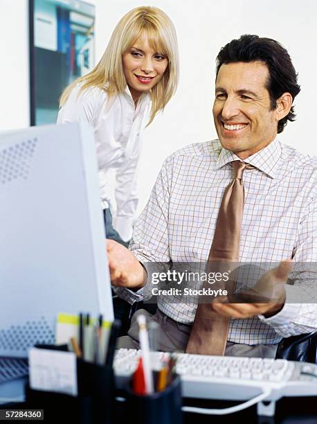 Watching Over Computer Two Business People Watching A Computer Screen And Smiling High-Res ...