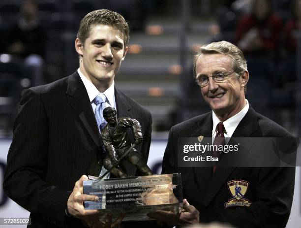 Matt Carle of the University of Denver poses with the trophy and presenter Kevin Milbery, after he won the Hobey Baker Award during the Hobey Baker...