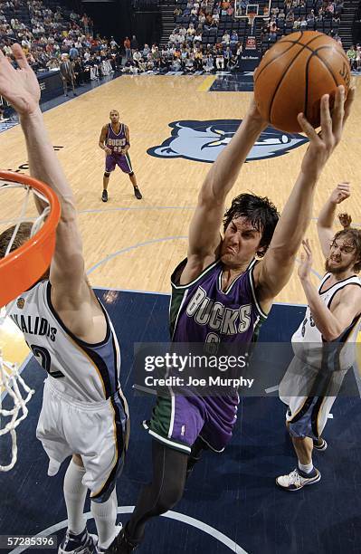 Andrew Bogut of the Milwaukee Bucks dunks over Jake Tsakalidis of the Memphis Grizzlies during a game between the Milwaukee Bucks and the Memphis...