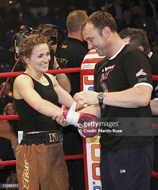 Ina Menzer of Germany and coach Michael Timm of Germany celebrate winning the WIBF World Championship Featherweight fight between Ina Menzer of...