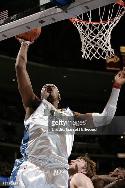 Carmelo Anthony of the Denver Nuggets goes to the basket against Troy Murphy of the Golden State Warriors on April 8, 2006 at the Pepsi Center in...