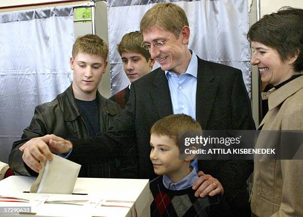 Accompanied by his family members, Hungarian Prime Minister Ferenc Gyurcsany from the Socialist Party helps his son Peter to vote in a polling...