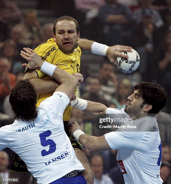 Mariusz Jurasik of Kronau Oestringen is attacked by Torsten Jansen and Bertrand Gille of Hamburg during the Handball DHB German Cup Final between HSV...