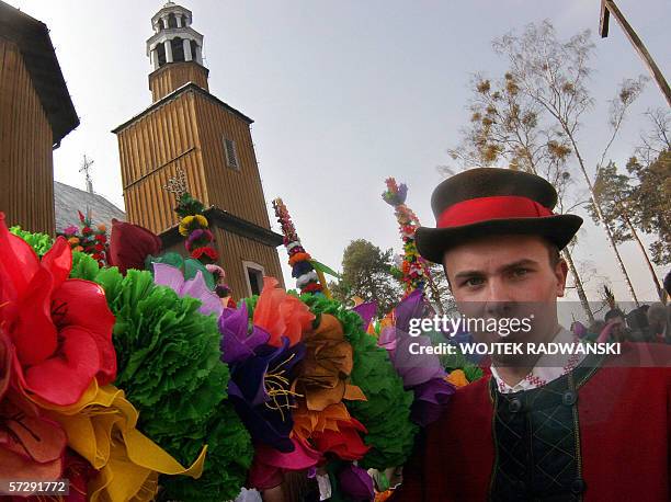 Polish man dressed in a traditional costume carries a giant traditional Easter palm during the Palm Sunday procession in Lyse, northeastern Poland,...