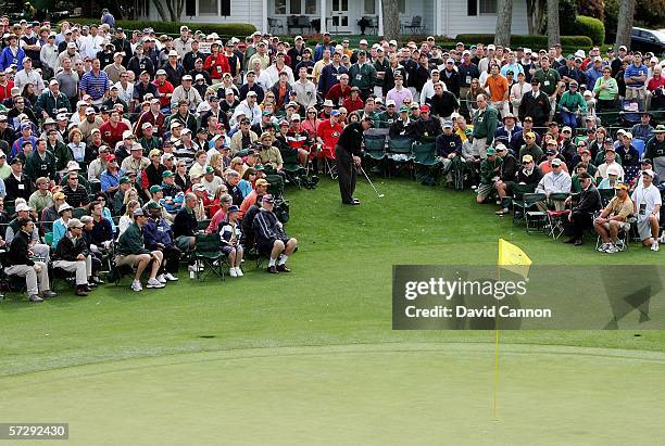 Phil Mickelson hits from the crowd to the 18th green during the continuation of the rain delayed third round of The Masters at the Augusta National...