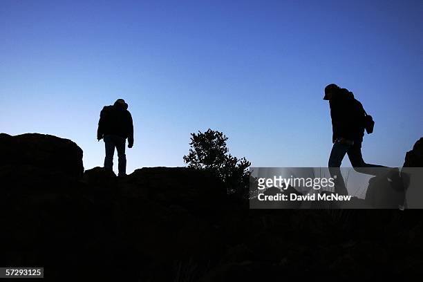 Minutemen Matt Sandt and Steve Callagy hike to their nighttime post looking over the U.S.-Mexico border as Minuteman Civil Defense Corps volunteers...
