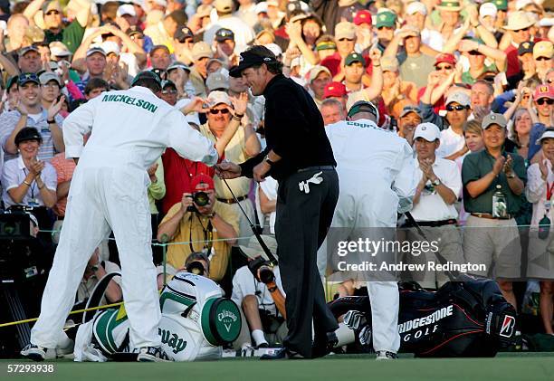 Phil Mickelson and his caddie, Jim McKay, celebrate on the 18th green after Mickelson won The Masters at the Augusta National Golf Club on April 9,...