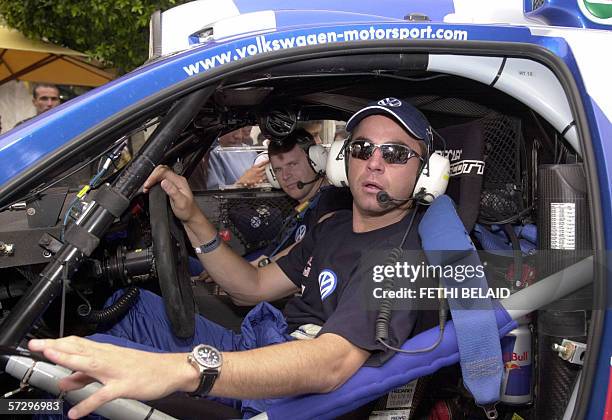 South African driver Giniel de Villiers and co-driver Dirk Von Zitzewitz pose in their Volkswagen upon arriving on Habib Bourguiba Avenue in Tunis,...