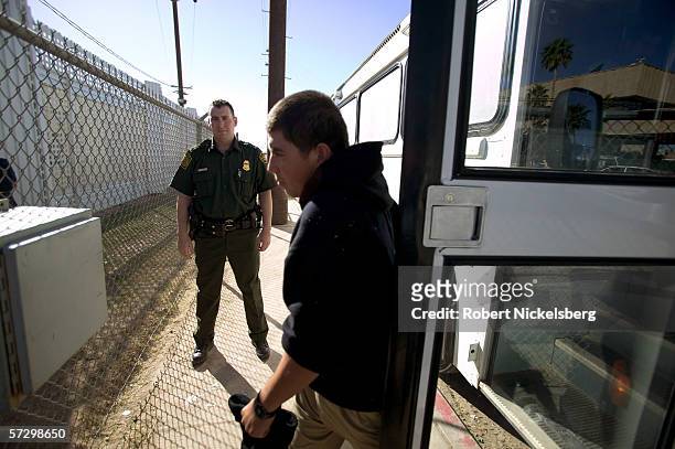 Customs and Border Protection agent watches as a Mexican national is deported from the US to Mexico at the Calexico-Mexicali border crossing fence on...