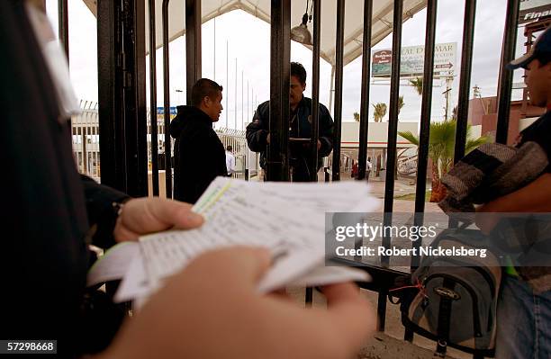 Mexican immigration officer inside Mexican territory, center right, questions a Mexican national who has been deported by Immigration and Customs...