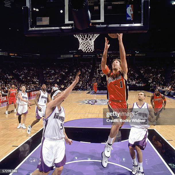 Troy Murphy of the Golden State Warriors reaches for the basket against Brad Miller and Francisco Garcia of the Sacramento Kings during the game at...