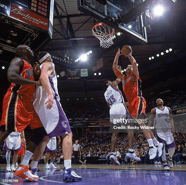 Troy Murphy of the Golden State Warriors reaches for the basket against Ron Artest of the Sacramento Kings during the game at Arco Arena on March 26,...