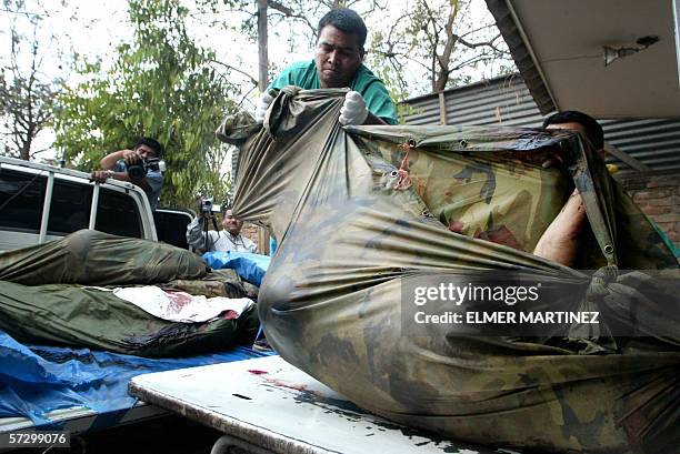 Tegucigalpa, HONDURAS: Un empleado de la Morgue Judicial carga el cuerpo sin vida de un militar, en Tegucigalpa el 10 de abril de 2006. Seis...
