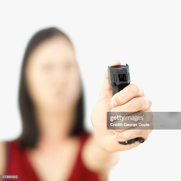 close-up of a young woman holding a pepper spray (blurred) - pulverizador de pimienta fotografías e imágenes de stock