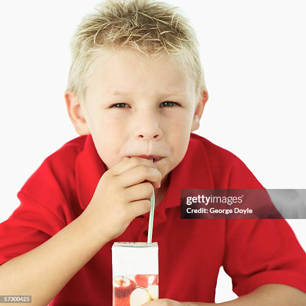 close-up of a boy drinking juice with a straw - juice box stock pictures, royalty-free photos & images